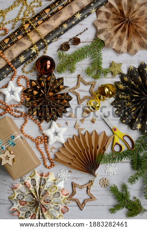 Christmas composition with decorative snowflakes, stars, wrapping paper on a light wooden background, top view. Christmas preparation concept. Vertical