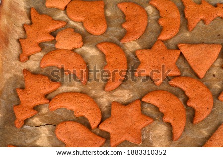 Christmas Gingerbreads cookies laid on baking paper on black baking sheet. Prepare Christmas gingerbread cookies