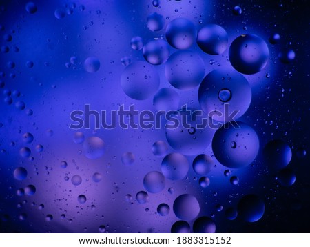 abstract galaxy in blue, simulated with oil drops in water.