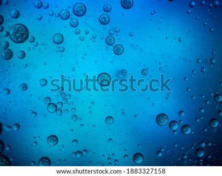 beautiful unreal background in blue consisting of oil drops in water.