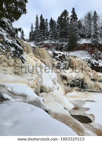 A Winter Waterfall Scene with Snow Covered Pine Trees