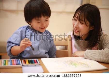 Image of a boy and a nursery teacher drawing