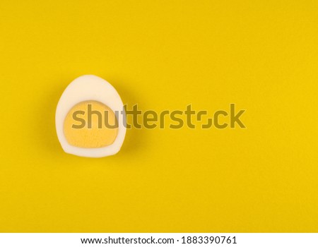 Hard boiled egg sliced in half in top view on bright yellow background. High quality photo