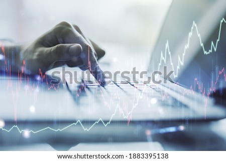 Double exposure of abstract creative financial chart with hand typing on computer keyboard on background, research and strategy concept