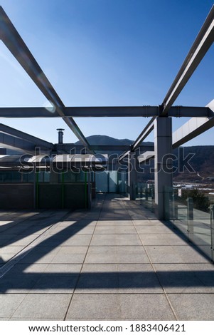 The steel frame installed on the roof of the building and the shadow look symmetrical.