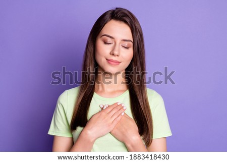 Photo portrait of dreamy pleased female student keeping hands on chest closed eyes isolated on vibrant purple color background
