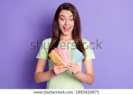 Photo portrait of excited screaming girl with open mouth holding many phones in two hands isolated on vivid purple colored background