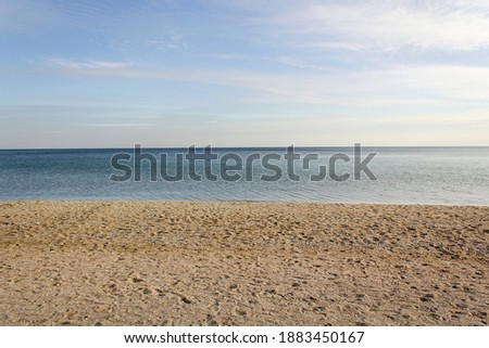 Blue sea water calm horizon line with empty sandy beach and sunny day sky relax meditation nature concept