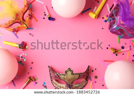 Frame of carnival masks and party decor on pink background, flat lay. Space for text