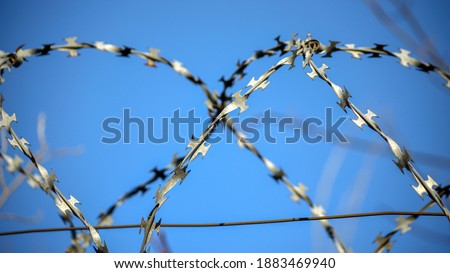 Barbed wire on blue sky background close up