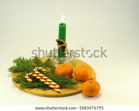 Tangerines, Christmas tree branch, caramel on a wooden tray.