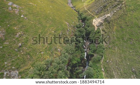 Green mountains path aerial. Rock mount stream river banks. Narrow way from hill to cloudy peak. Cinematic nobody nature landscape of Arran Island, Scotland. Summer vacation at greenery ranges