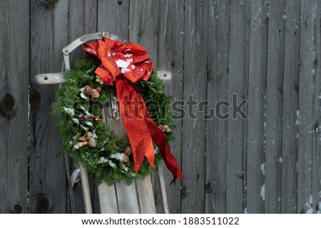 Sled on a fence with a Christmas wreath