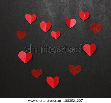 Heart made of red paper hearts on a black background. Banner. Festive banner. Copy space