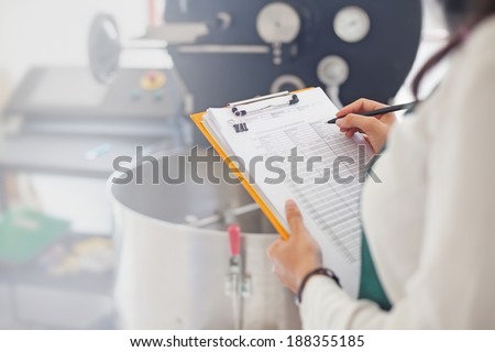 Hand signing document about coffee roasting at factory Royalty-Free Stock Photo #188355185