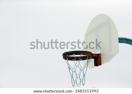 an outdoor basketball hoop in winter