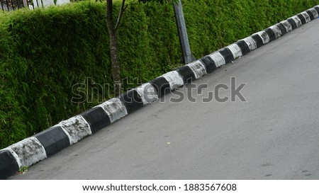 Concrete sidewalk with black and white curb