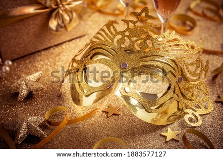 Venetian golden carnival masks on golden background. Concept of mardi gras mask or disguise, New Year party