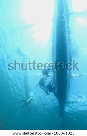 Boat and diver silhouette under water with beautiful sun ray.