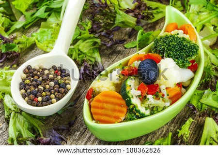 Vegetables in green dish on a wooden table
