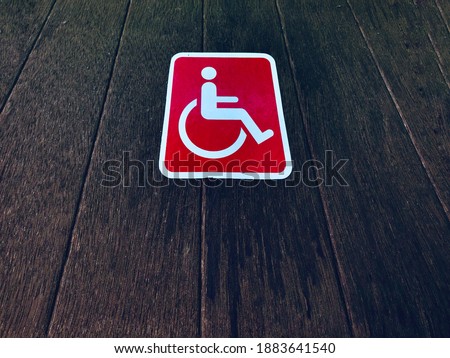 Handicapped symbol on dark wood door for disable icon background and texture.