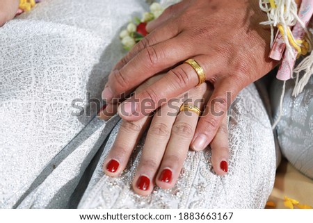 wedding Rings on the fingers of the bride and groom at a Thai ceremony