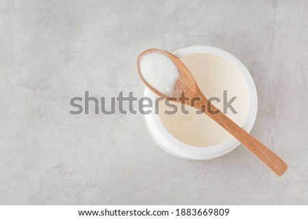 collagen powder in a spoon on a gray table, top view, heart,  Royalty-Free Stock Photo #1883669809