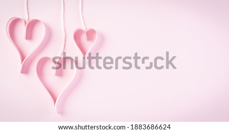 Love and Valentine's day concept. Pink paper hearts on pastel paper background. Flat lay top view with copy space.