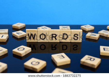 Words word made of wooden letters on a mirror surface on a blue background