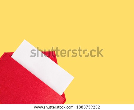 Red open envelope with a sheet of paper mock up on a yellow background with copyspace and mock up. Valentine's day holidays concept and love notes, christmas and new year  letters for Santa Claus