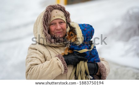 Aged woman with her dog. Selective focus.