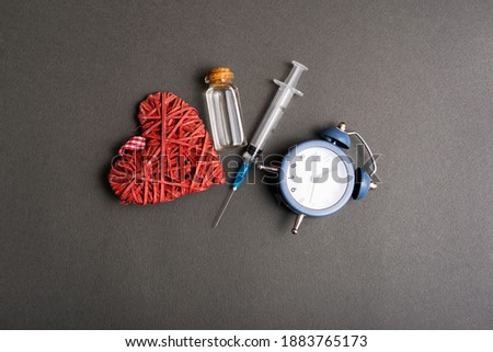 Time to vaccinate, photo of clock vaccine and heart