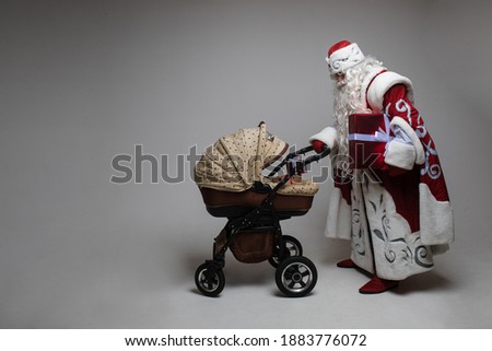 picture of old santa claus walks witha baby stoller