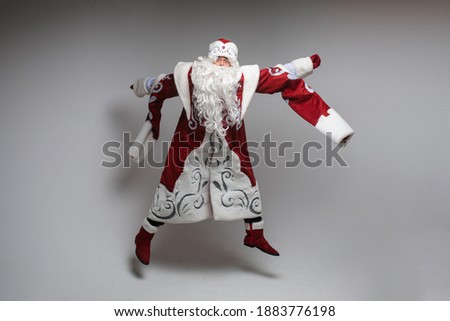 picture of old santa claus jumps and rejoices in the studio