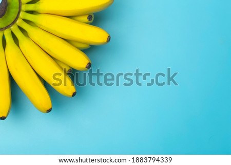 Bananas background. Bananas on a pure blue background. Summer, vegetarian food, smoothie and tropical background concept.