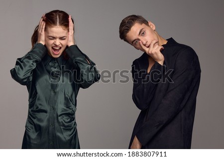Calm man and irritated woman on gray background emotions conflict