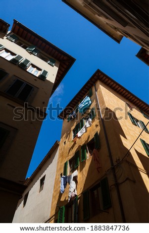 Laundry out to dry from windows of a residential building in Florence, Italy on a clear, summer day. 
