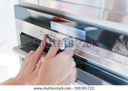 Hand moving the timer knob on the oven 