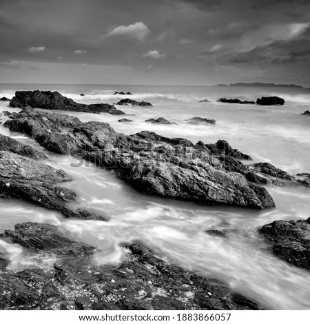 rocky beach in black and white. long exposure effect. located at Terengganu, Malaysia. soft and grain image.