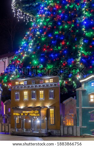 Christmas decorations under a huge Christmas tree in Burgas' city centre. Colourful wooden houses used as decorations. Translation on the house is Mail for Santa Claus. High quality photo