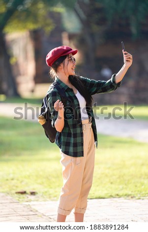 Asian tourist woman taking photo by smartphone at ancient city,  Ayutthaya Thailand.