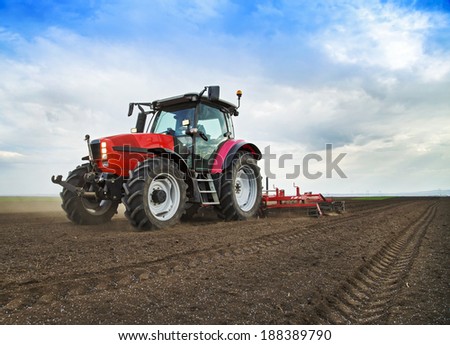 Farmer in tractor preparing land for sowing Royalty-Free Stock Photo #188389790