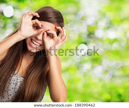 portrait of young woman doing a glasses gesture closeup