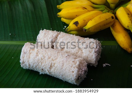 Popular Steamed Kerala Breakfast Dish served in banana leaf with yellow banana, Puttu and yellow small banana served in banana leaf