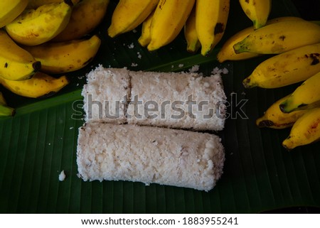 Popular Steamed Kerala Breakfast Dish served in banana leaf with yellow banana, puttu and yellow small banana served in banana leaf top view