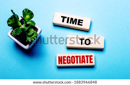 TIME TO NEGOTIATE is written on wooden blocks on a light blue background near a flower in a pot