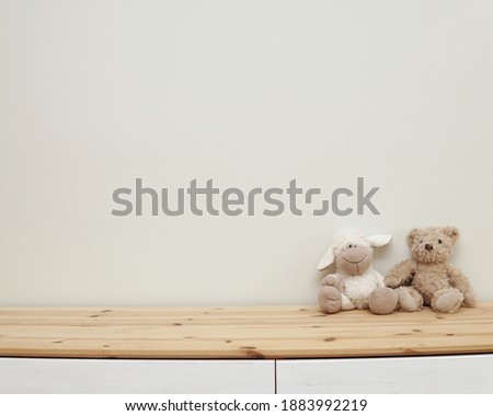 Nursery wall mockup, blank wall for decal, sticker, framed art display, wooden shelf and soft toys, neutral baby room interior, space for text. Royalty-Free Stock Photo #1883992219