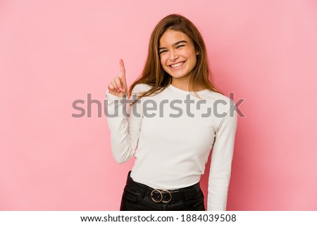 Young skinny caucasian teenager girl showing number one with finger.