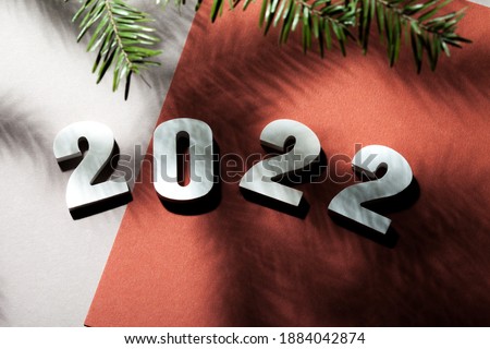 Alphabet 2022 from white numbers on a background of red colored paper. Shadows