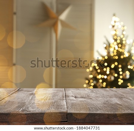 Empty wooden surface and blurred view of room decorated for Christmas, space for text. Interior design